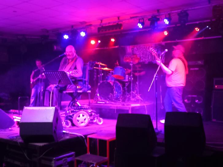 A band plays on a stage with lighting