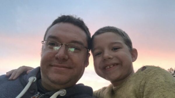 A man and a boy smile for thr camera