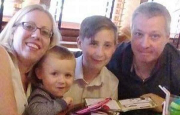 A family of four smile for the camera