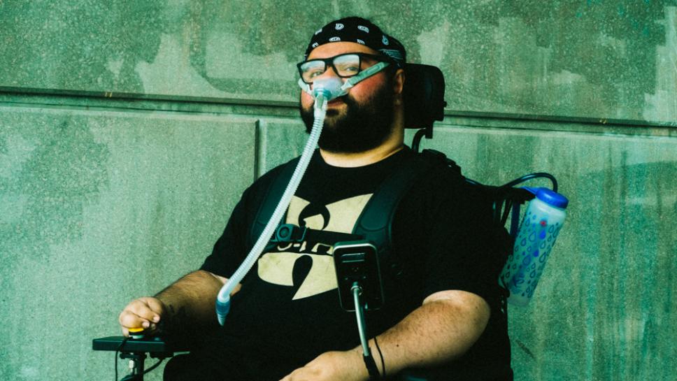 A man wearing a bandana poses for the camera