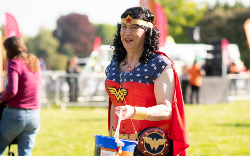 Fundraiser dressed as Wonder Women holds a collection bucket