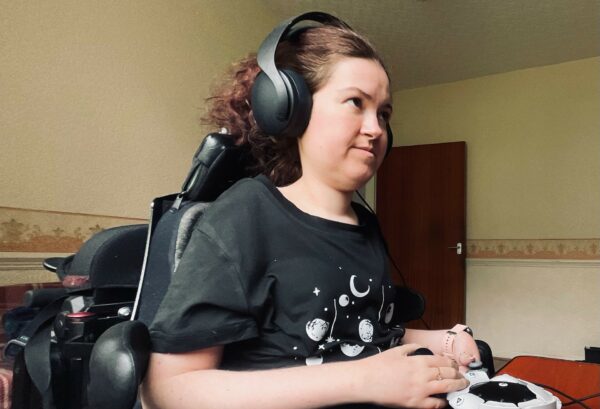 A women playing on her computer using a controller