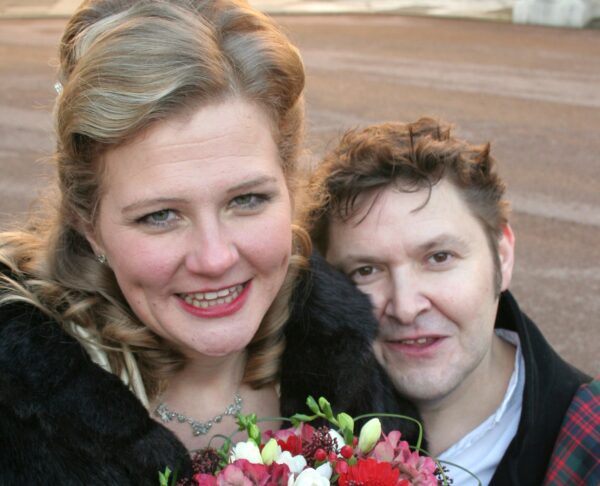 Happy couple pose with flowers on their wedding day
