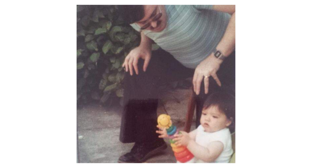 A baby with its dad holding a toy car