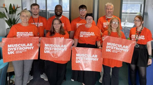 A fundraising team holding MDUK banners