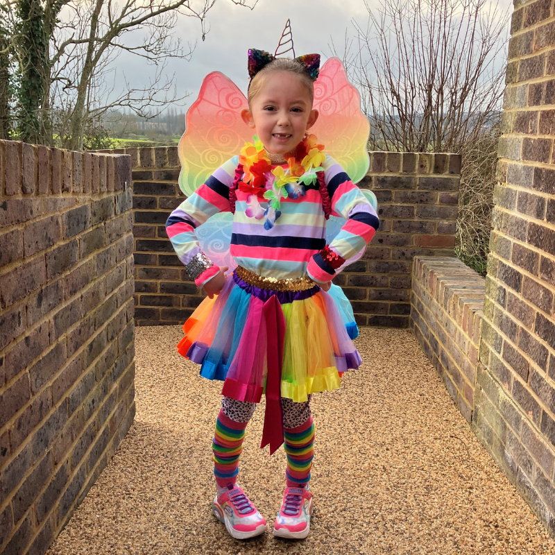 Josie is wearing a brightly coloured outfit with a multi-coloured tutu, a unicorn headband and fairy wings