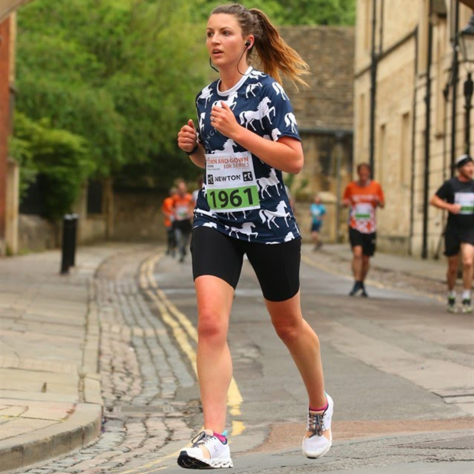 Action shot of Alice running through the streets of Oxford for the Town & Gown race