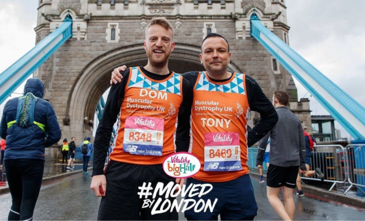 Two #TeamOrange runners standing on Tower Bridge at the Big Half in 2019