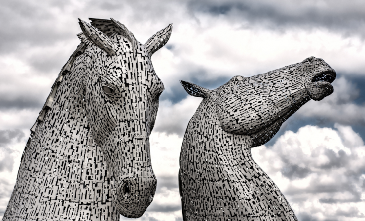 Close up image of the kelpies in falkirk with cloudy sky in the background