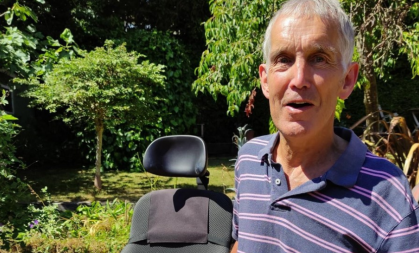 Image of Andy Davies in the garden, next to a wheelchair
