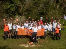 Source to sea group picture with everyone's arms in the air and a big orange MDUK banner