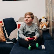 Boy sitting on hos bed playing video games